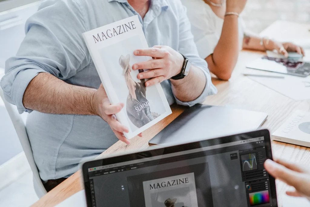 Présentation de magazine imprimé lors d’une réunion de design graphique et mise en page éditoriale.